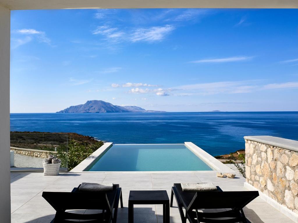 a swimming pool with a view of the ocean at Arpathea Villas in Foiníkion