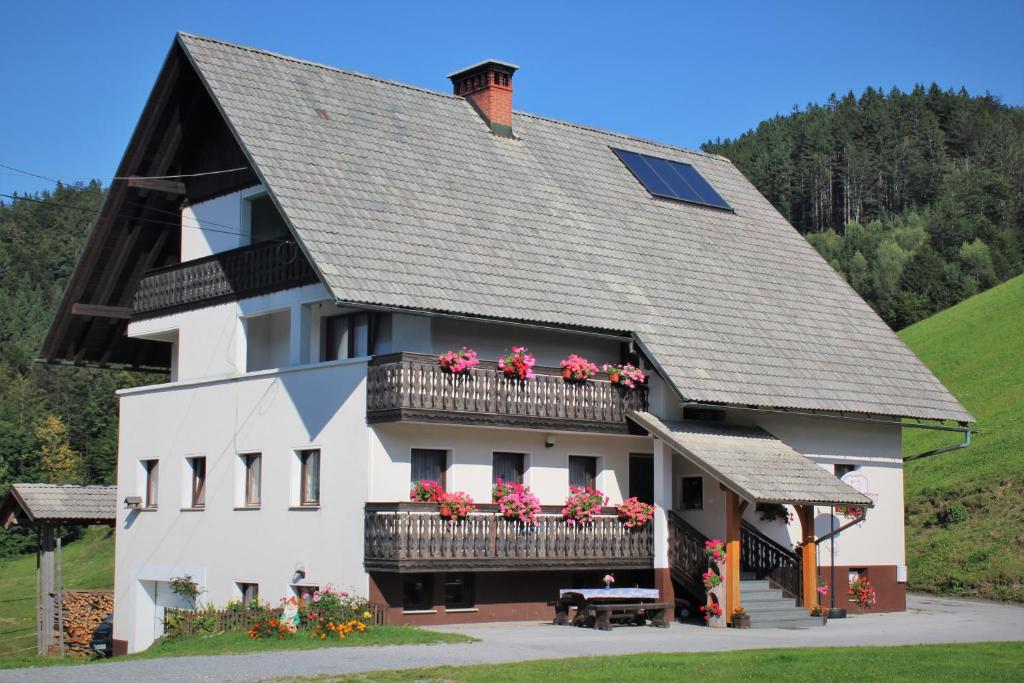 un gran edificio blanco con flores en los balcones en Apartments Peternelj, en Cerkno