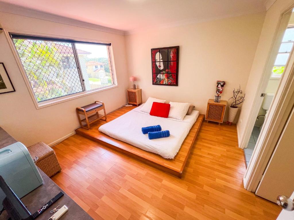 a bedroom with a bed with two red pillows on it at Vista Air conditioned Holiday Dream Castle Youth Hotel in Brisbane