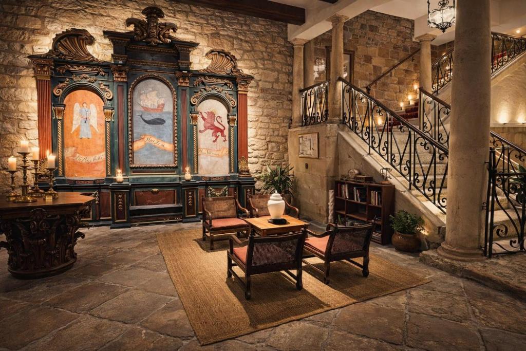 a room with a staircase and a table and chairs at Palacio Pampinot in Hondarribia