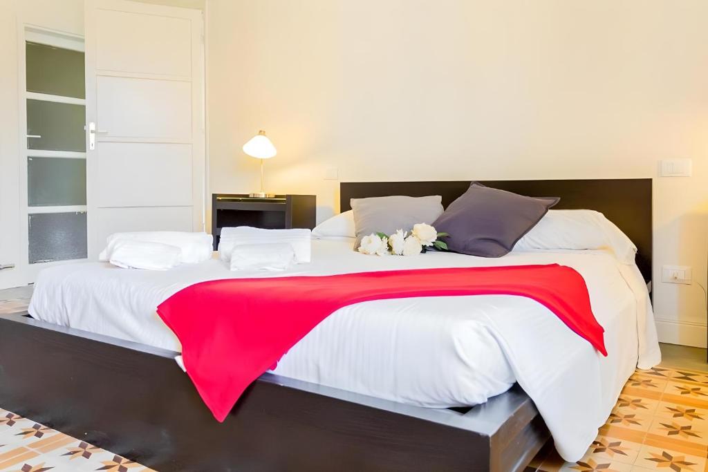 a large bed with a red blanket on it at InnPisaRentals2- Casa dei Cavalieri in Pisa
