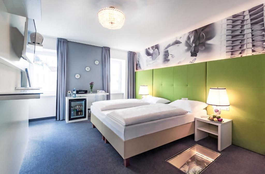 ウィーンにあるブティック ホテル ドナウワルツァーの緑の壁のベッドルーム1室(大型ベッド1台付)