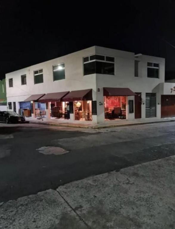 a large white building with a parking lot at night at Hostal el búho Morelia in Morelia