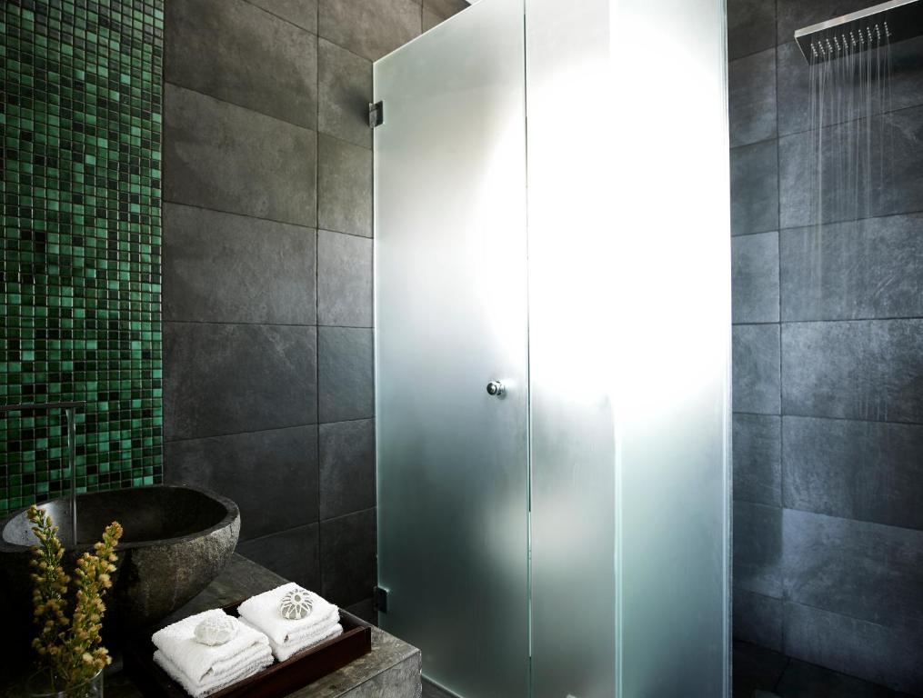 a shower stall in a bathroom with towels at Arpathea Villas in Foiníkion