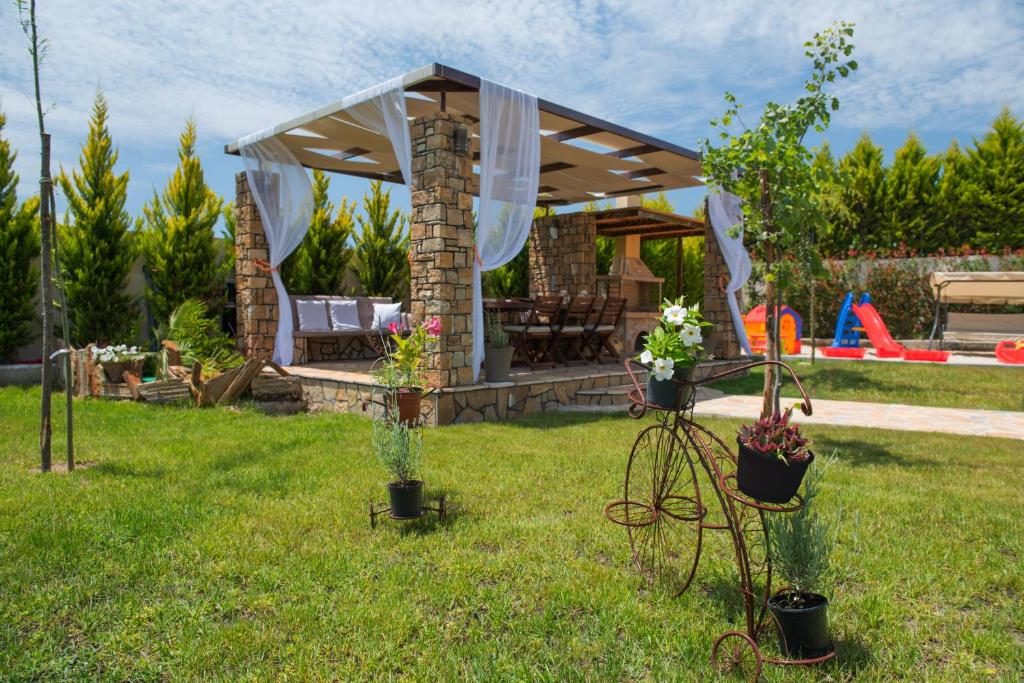 a garden with a gazebo in the grass at Anthemida Rooms in Sykia Chalkidikis
