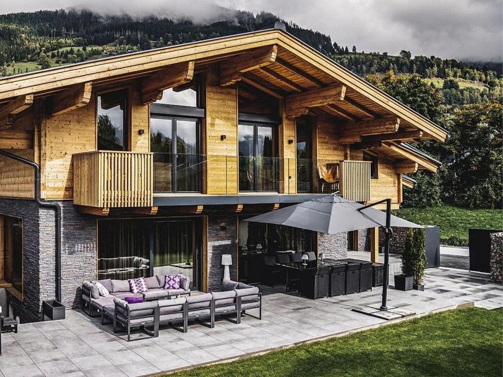 a house with a couch and an umbrella in front of it at Chalet Amadeus by we rent in Piesendorf