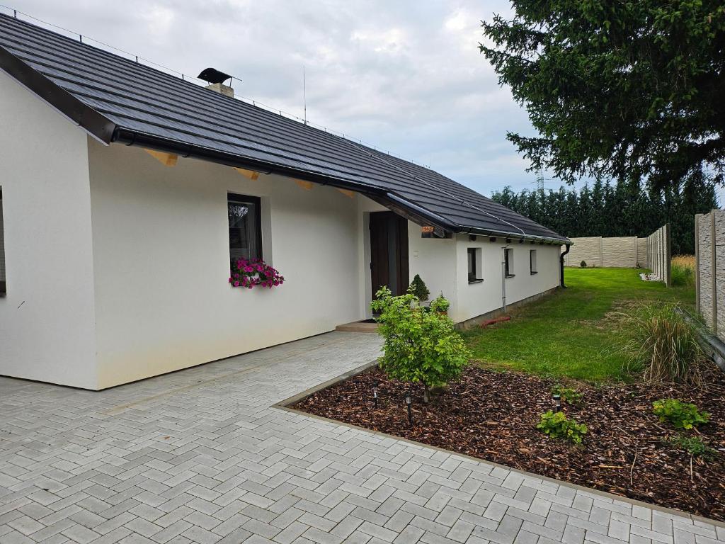 a white house with a window and a yard at Chalupa uprostred niceho in Hlinsko