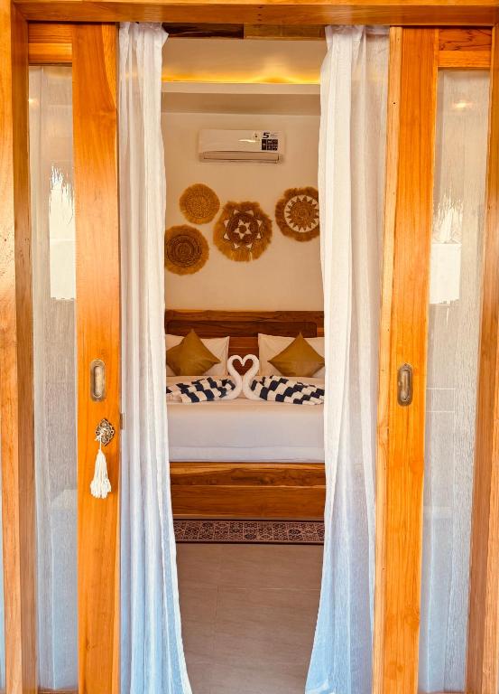 a view of a bedroom through a glass door at The Lauk private in Gili Islands
