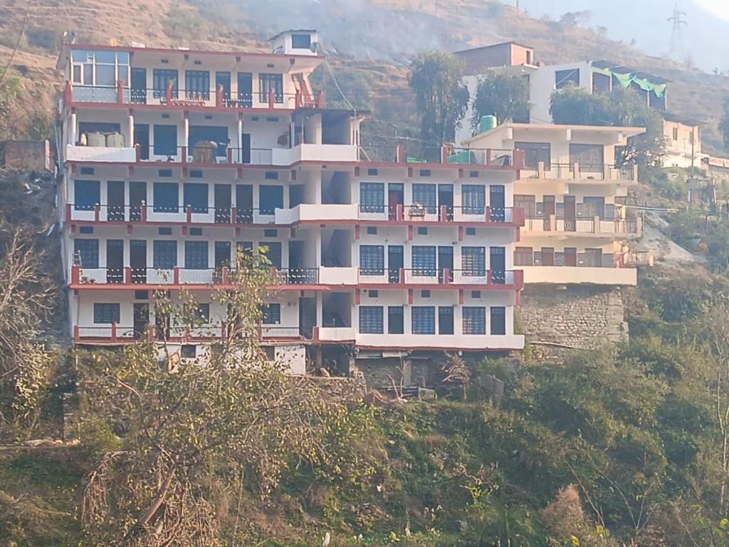 a large building on the side of a hill at Hotel Kalyan Palace And Restaurant in Pīpalkoti