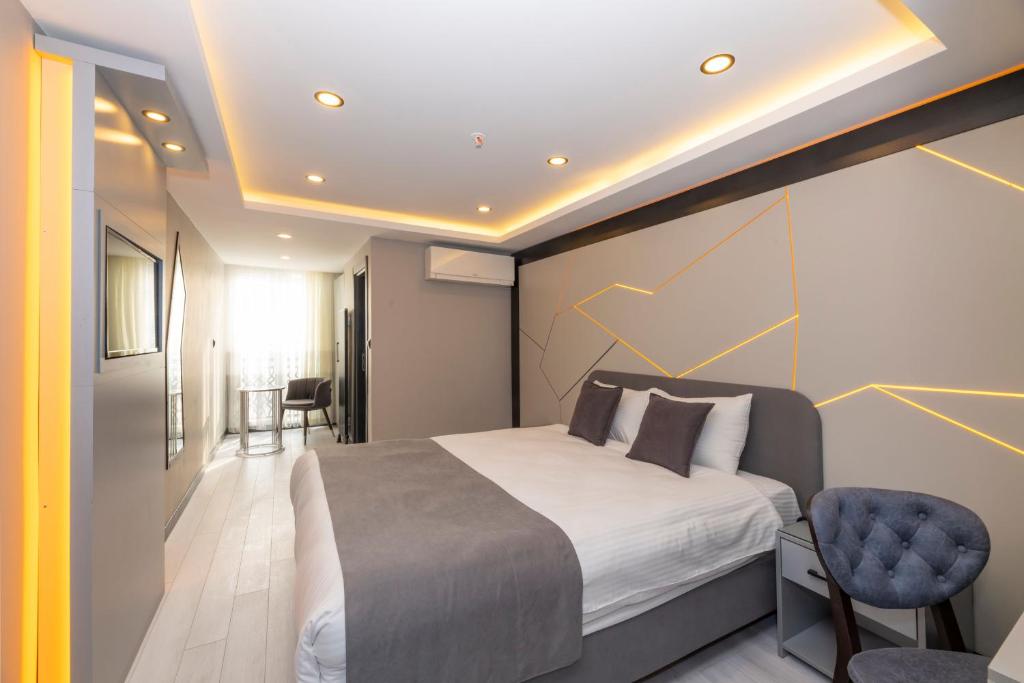 a bedroom with a large bed and a blue chair at White Corner Hotel in Istanbul