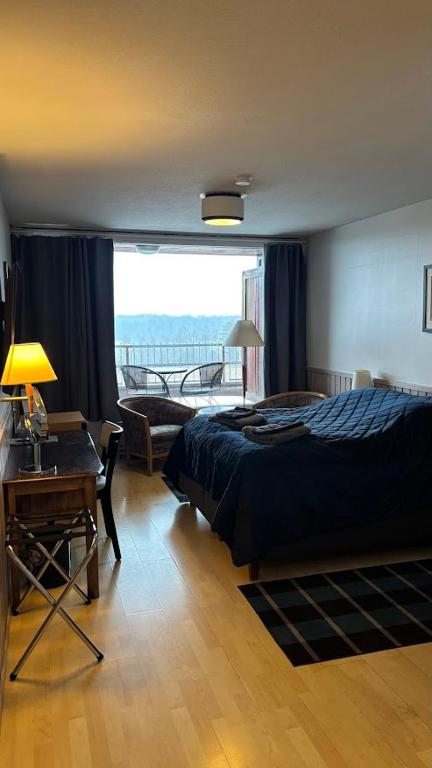 a bedroom with a bed and a desk and a window at Hotelli Kantakievari in Ruovesi