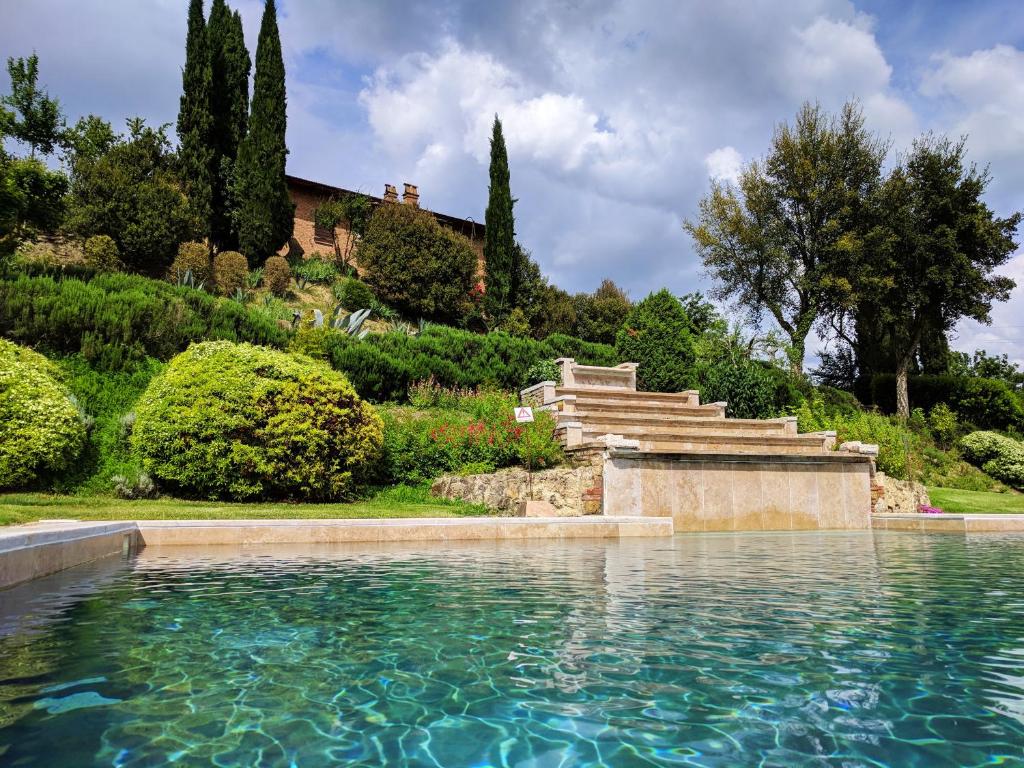 a pool of water in front of a house at Wild Agriturismo Podere della Bruciata in Chiusi