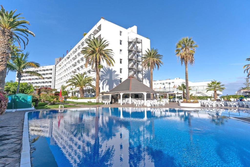 a large hotel with a swimming pool and palm trees at BLUESEA Interpalace in Puerto de la Cruz