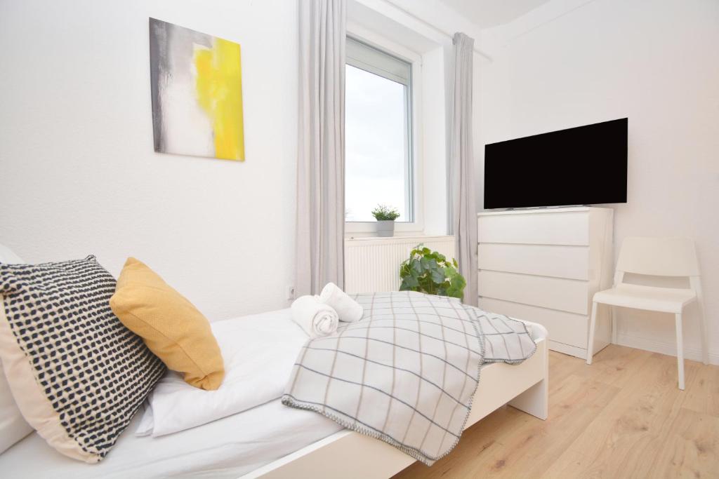 a white living room with a white couch and a television at Unterkunft für Facharbeiter in Forchheim in Forchheim