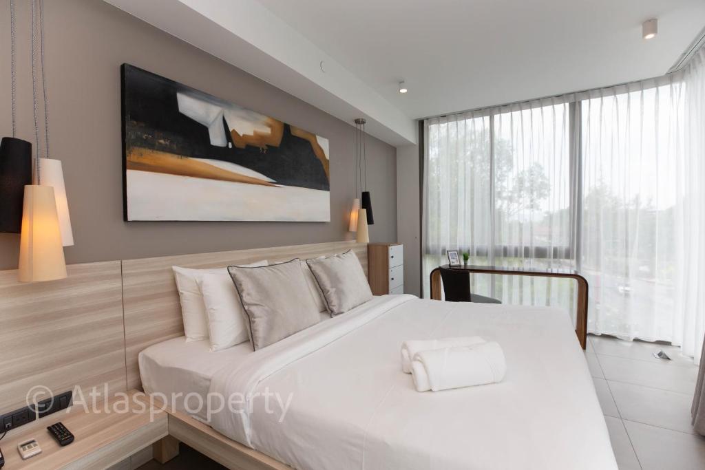 a bedroom with a white bed and a large window at Oceanstone- 2BDR apartment in Ban Thalat Choeng Thale