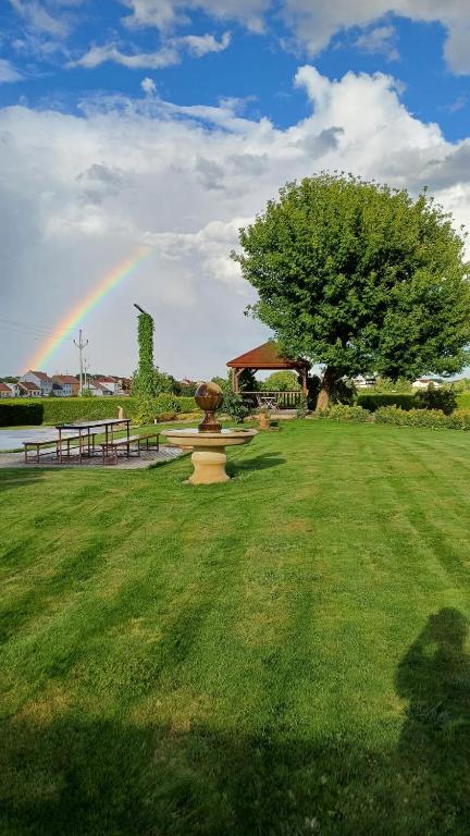 a rainbow in a park with a fountain in the grass at Apartmány Vinařství Tesařík in Prušánky