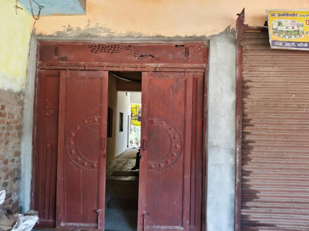 an old red door in a building with a gate at Virendra Home Stay in Kartal
