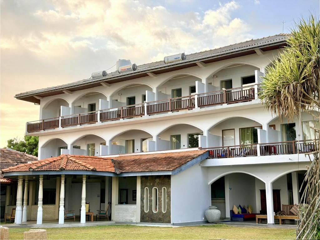 an image of a large white building at Sri Gemunu Beach Resort in Unawatuna