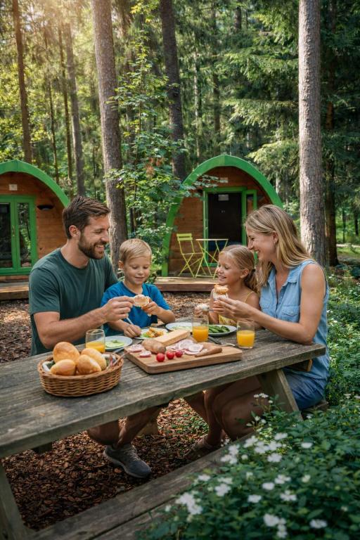 a family sitting at a picnic table eating food at NATURAMA Brombachsee Trollwald in Pleinfeld