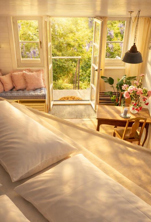 a bedroom with a bed and a table and windows at Boutique Loft Studio in Kreuzlingen