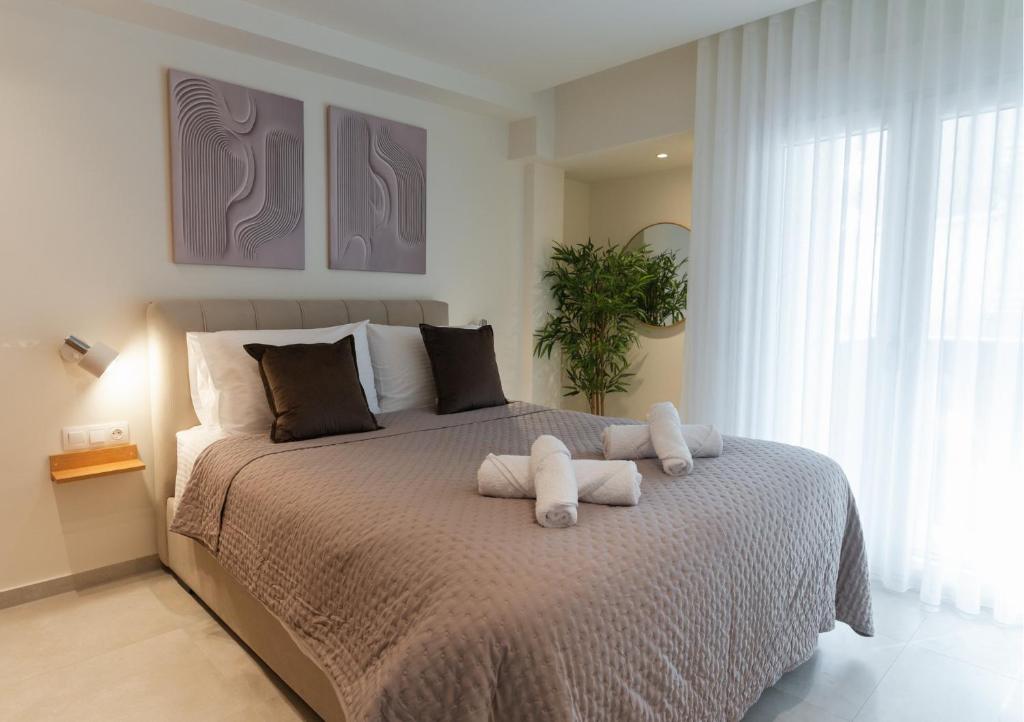 una camera da letto con un letto con due asciugamani sopra di Opus Boutique Apartment a Alexandroupoli