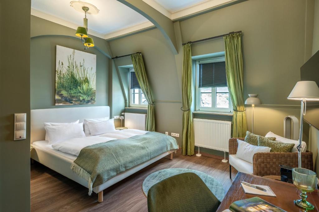 a bedroom with a bed and a table at Hotel Würzburger Hof **** in Würzburg