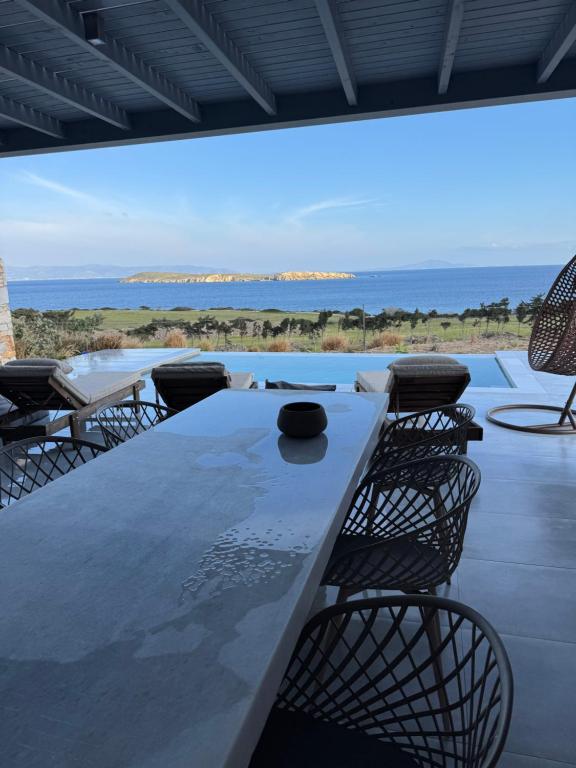 a table with chairs and a view of the ocean at Drios Hillhouse II in Drios
