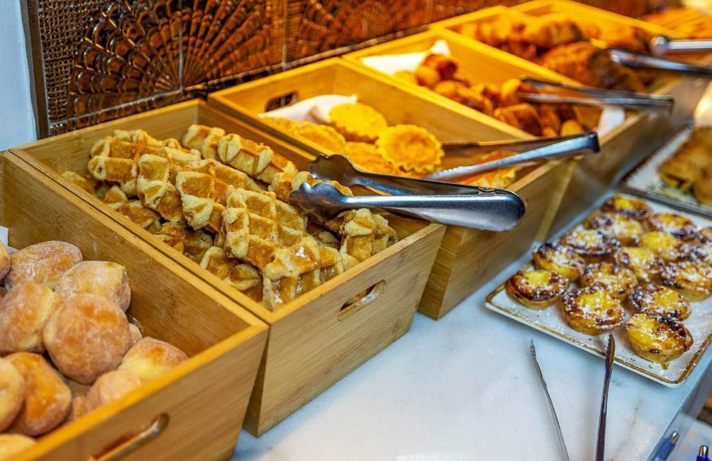 Wooden buffet boxes display assorted pastries and sweet breakfast pastries.