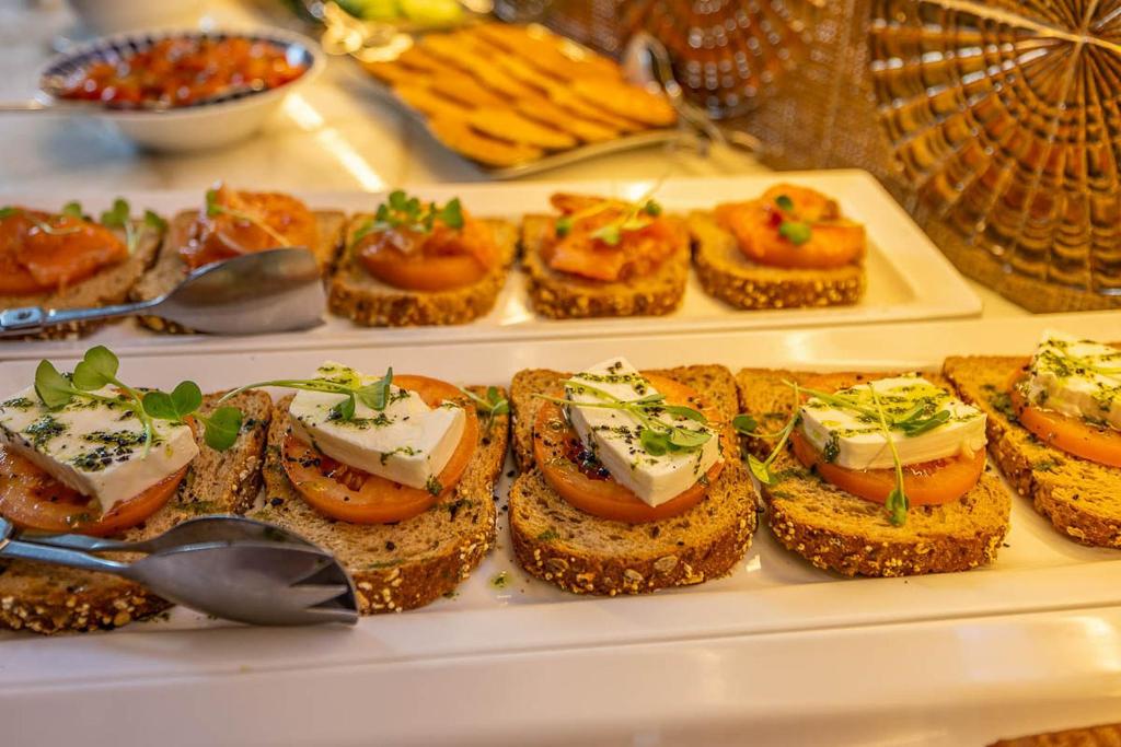 A buffet displays open-faced toast and canapé-style breakfast bites.