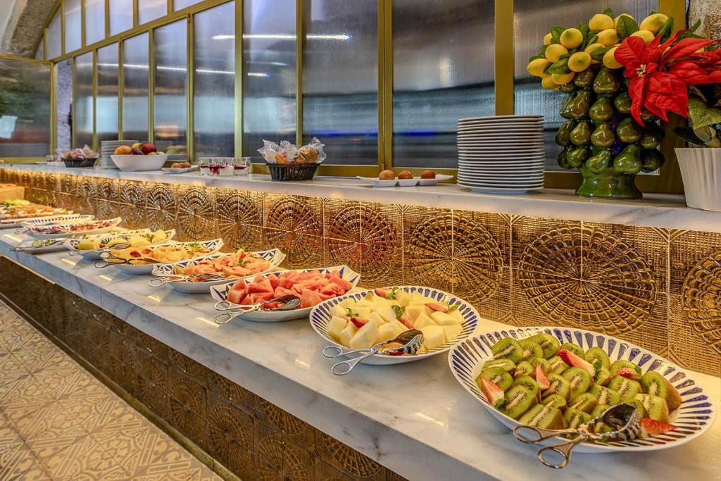 A generously presented buffet with fruit, salads and stacked plates.