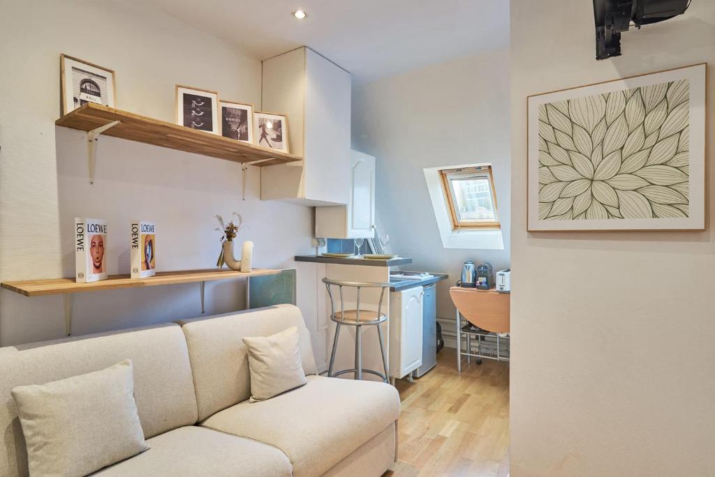a living room with a couch and a kitchen at Charming Studio Arc de Triomphe Monceau in Paris