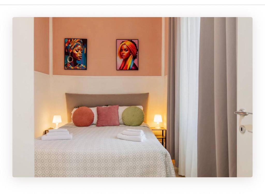 a bedroom with a bed with three pictures on the wall at Appartamento la Speranza in Grosseto
