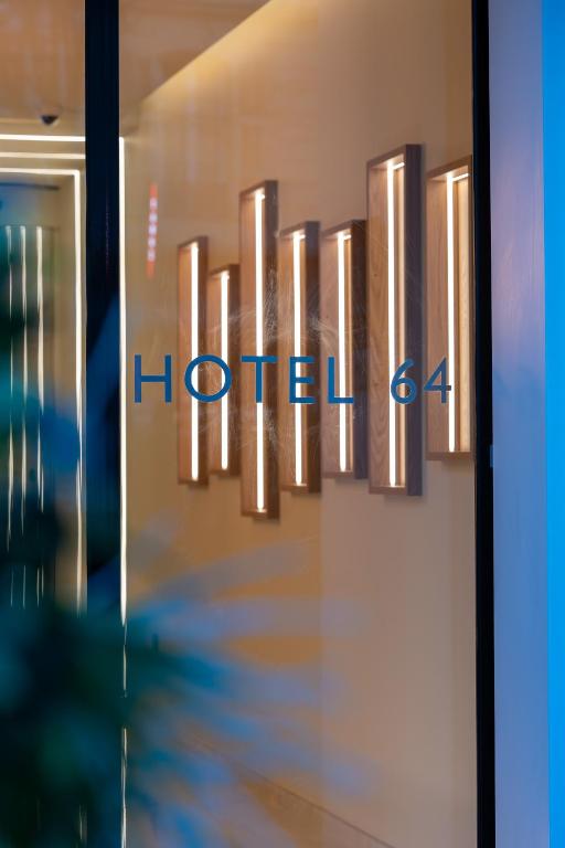 a sign for a hotel on a wall at Hotel 64 Nice in Nice