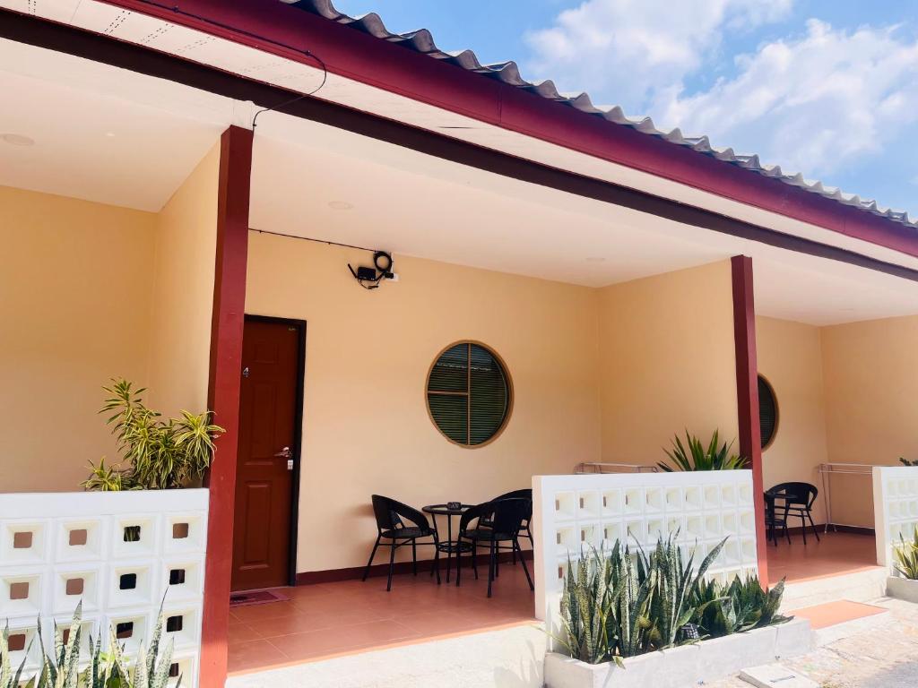 a patio with chairs and a table on a house at Muttafa House in Nai Yang Beach
