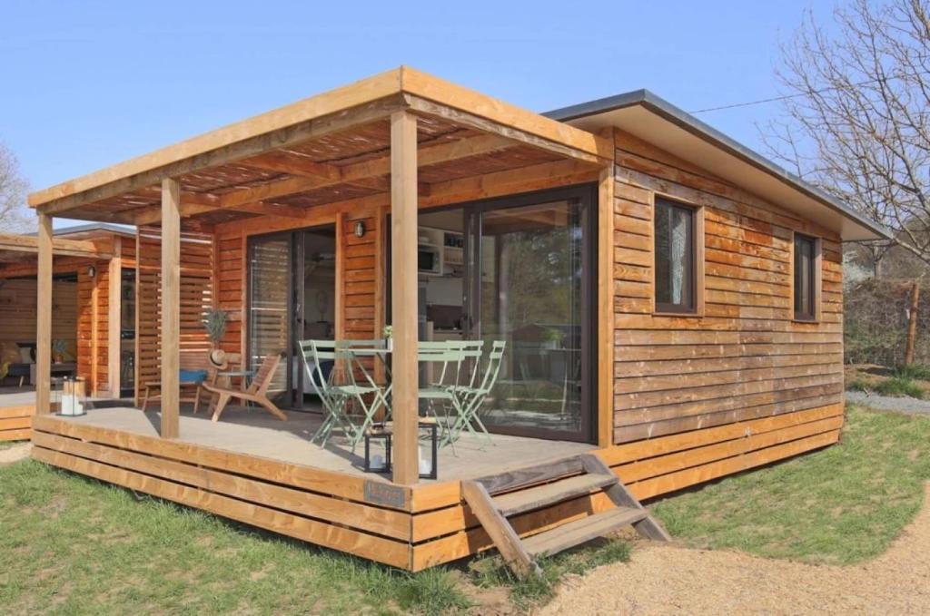 a log cabin with a deck with a table at Camping 3 étoiles - ccbfggd in Lepin-le-Lac