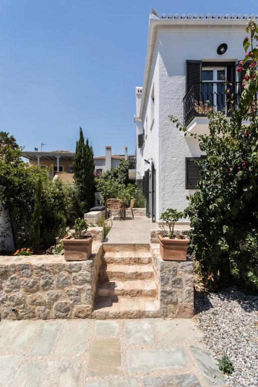a stone walkway in front of a white house at Eagle House Spetses 4 bedrooms in Spetses