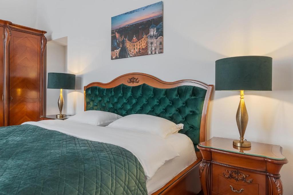 a bedroom with a green bed and two lamps at Casa Doseanu , Stern Palace Historic Residence in Oradea