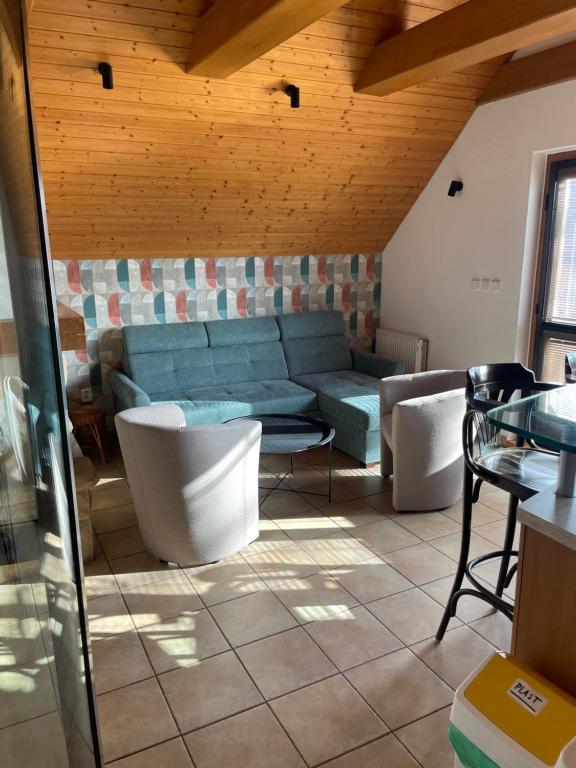 a living room with a blue couch and chairs at Vinný sklep Tesařík in Prušánky