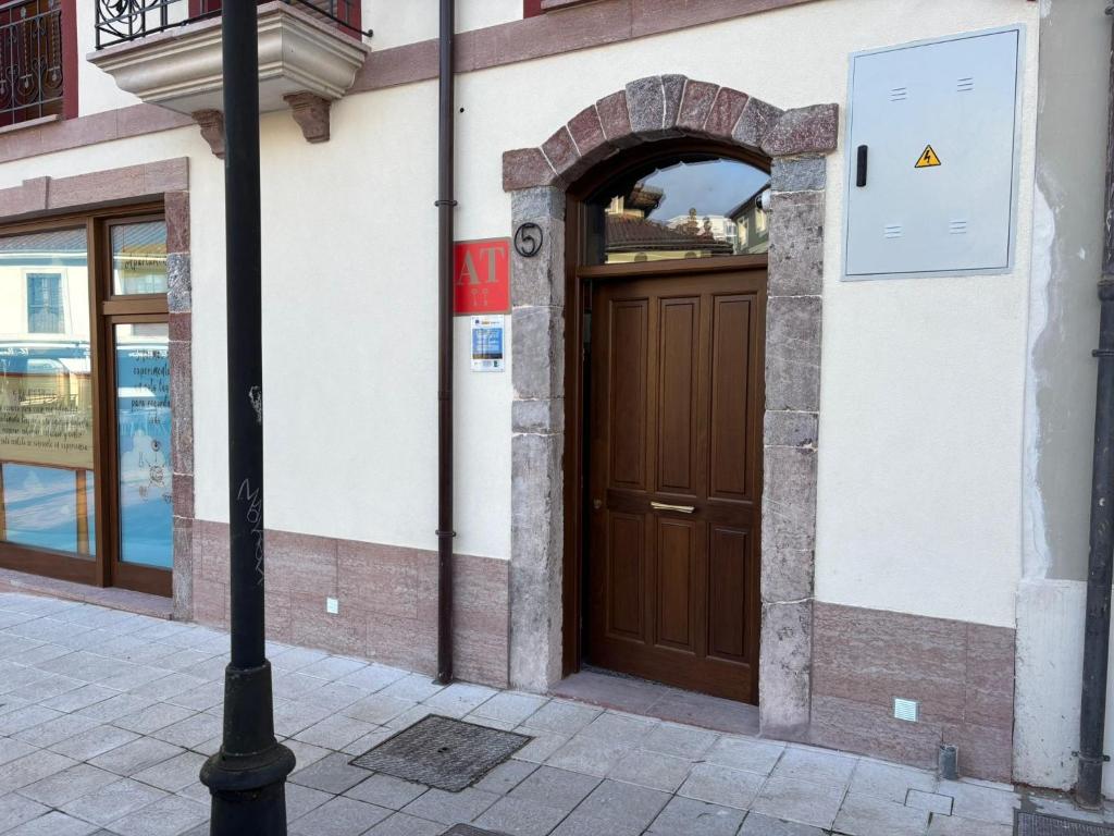 a brown door on a building with a pole at Apartamentos Los 5 Sentidos in Grado
