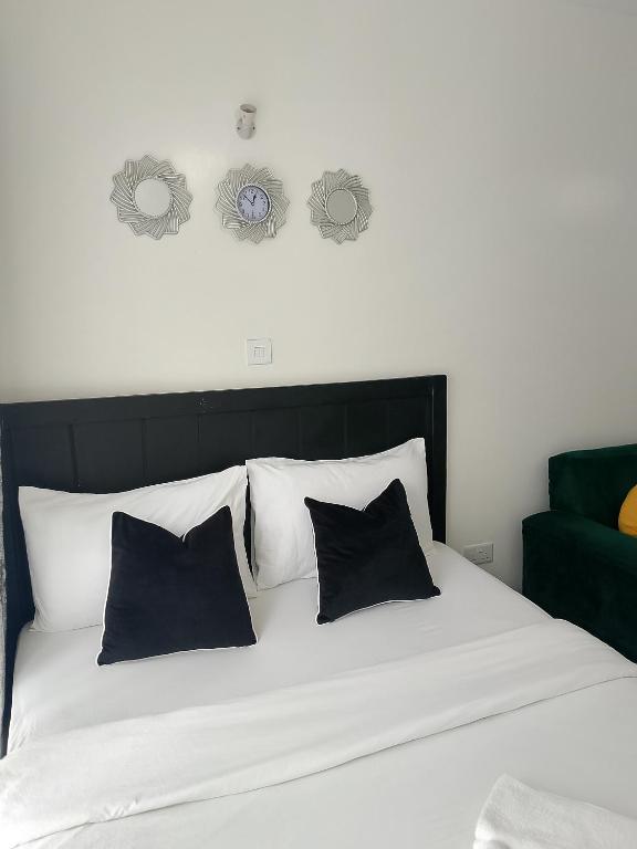 a bed with black and white pillows on it at Home Away in Ongata Rongai 