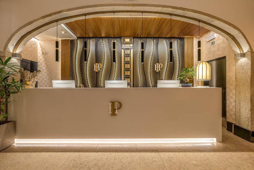 A polished reception desk sits beneath a stone arch and decorative wood-panelled wall.