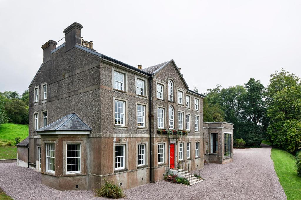 a large brick building with a red door at Dripsey Castle Estate in Dripsey