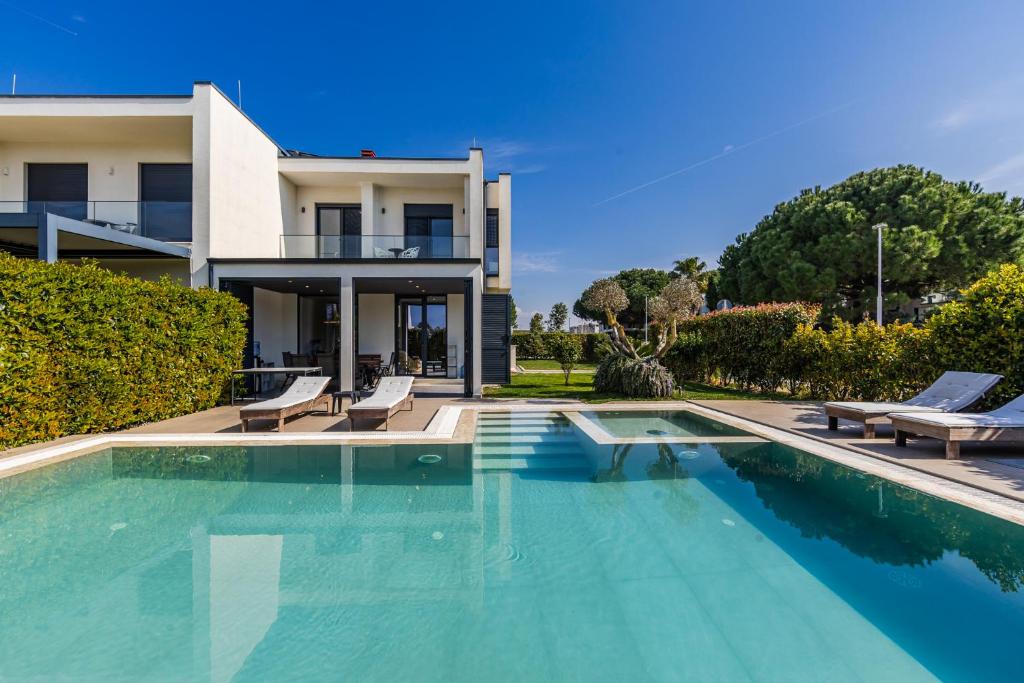 a swimming pool in front of a house at Villa AMMA Pool & Jacuzzi by PikHost in Draç