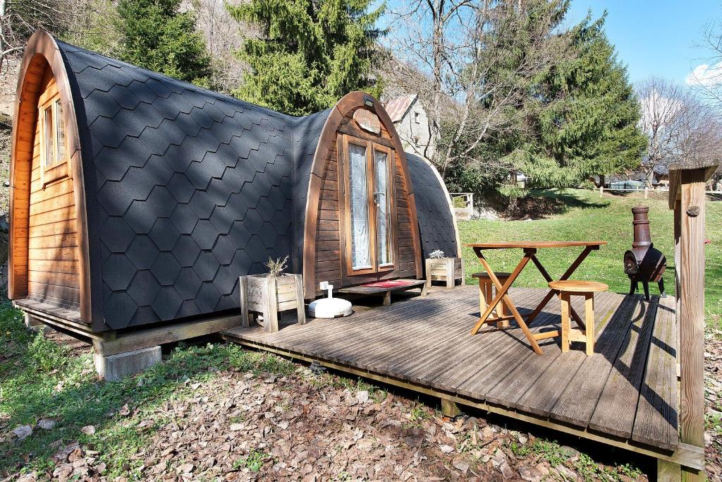 a small house with a wooden deck and a table at Cabane Perce Neige - Gavarnie in Gèdre