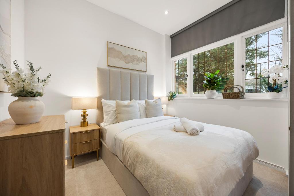 a bedroom with a large white bed and windows at Modern 2 Bed Apartment by MCF in Merstham