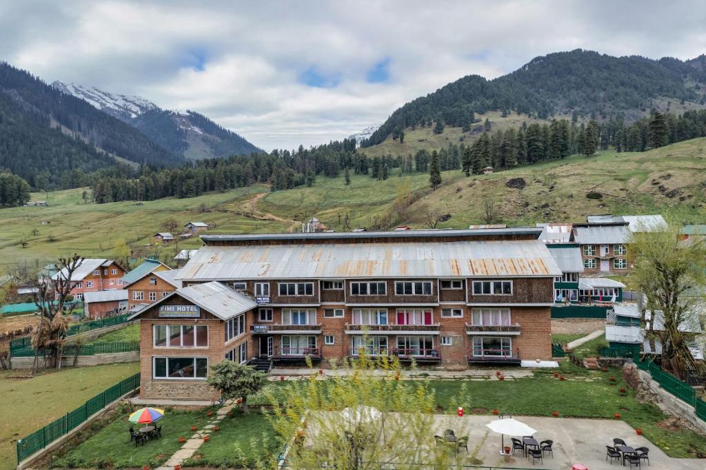 a large building in the middle of a mountain at Fimi hotel aru valley pahalgam in Ārau