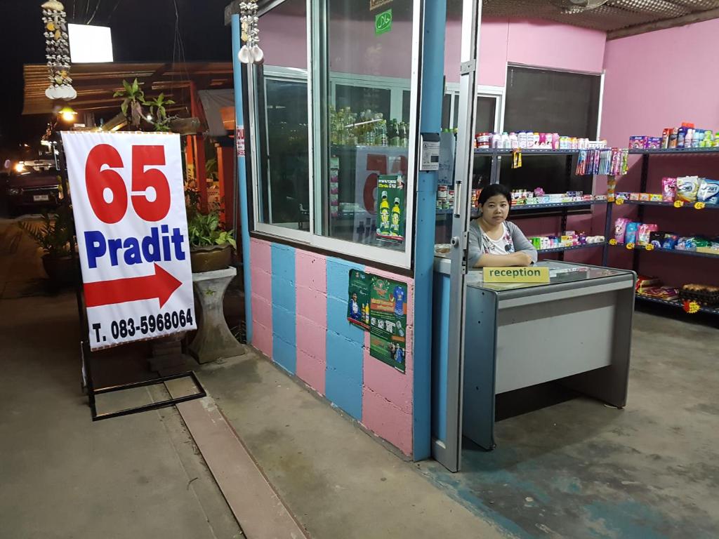 een vrouw die aan een toonbank in een winkel staat bij 65 Pradit in Nai Yang Beach