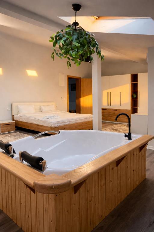 a bath tub in a room with a bed at Nesto Rooms in Sighetu Marmaţiei