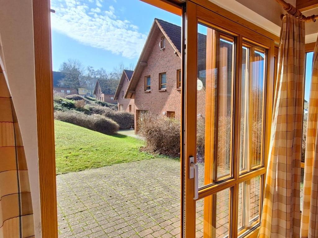 an open door with a view of a house at Haus 24 im Natur Ferienpark, Perfekt für Hundeliebhaber, Wanderfreunde und Naturliebhaber in Nieheim