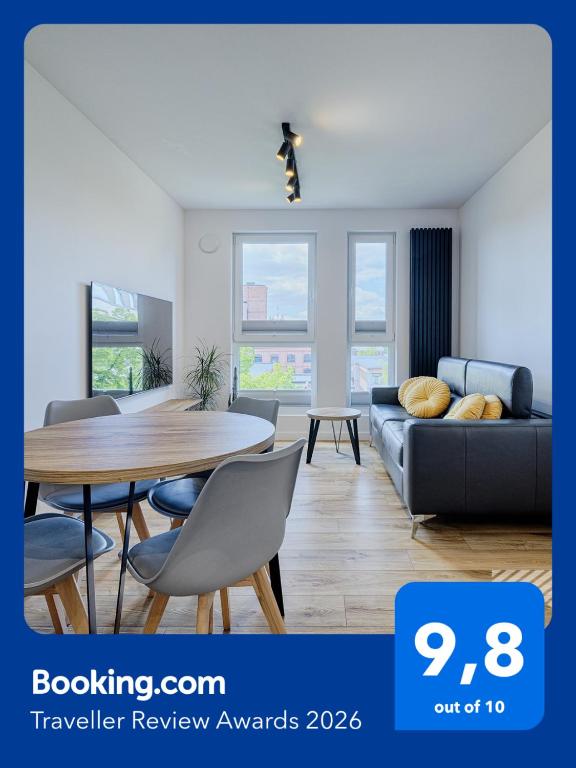 a living room with a table and a couch at Slovianka Sky View by LookAp - basen, sauna oraz darmowy parking!! in Łódź